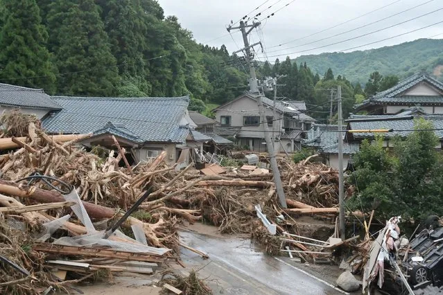 Debris washed in by heavy rains and flooding litters a neighbourhood in the city of Murakami, Niigata Prefecture, on August 4, 2022, after heavy rains hit the northern areas of Japan. Bridges collapsed and rivers burst their banks as heavy rain lashed northern Japan on August 4, with 200,000 residents urged to evacuate as authorities warned of dangerous flooding. (Photo by JIJI Press/AFP Photo)
