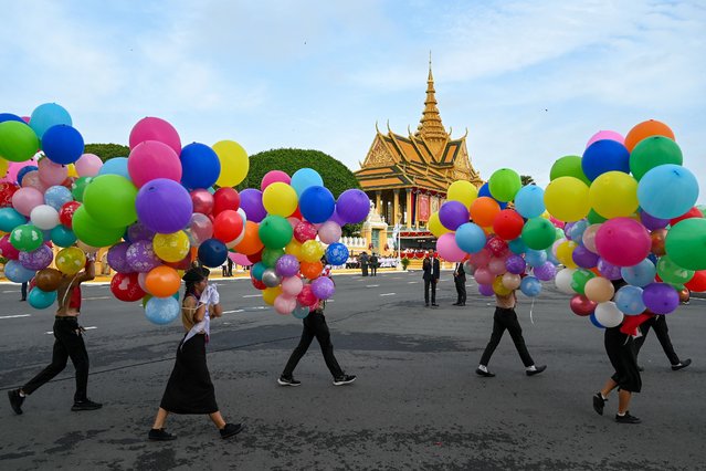 Students carry balloons during Independence Day celebrations in front of the Royal Palace in Phnom Penh on November 9, 2023, as Cambodia celebrates the 70th anniversary of its independence from France. (Photo by Tang Chhin Sothy/AFP Photo)
