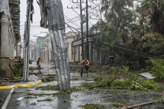 Fallen electricity lines, metal and tree branches litter a street after Hurricane Ian hit Pinar del Rio, Cuba, Tuesday, September 27, 2022. (Photo by Ramon Espinosa/AP Photo)