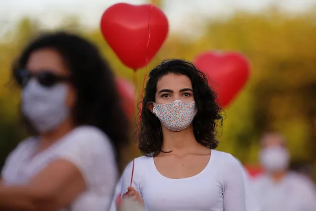 Artists perform with red balloons at a protest in honor of people who died from coronavirus disease (COVID-19) during its outbreak in Brasilia, Brazil on June 1, 2020. (Photo by Adriano Machado/Reuters)