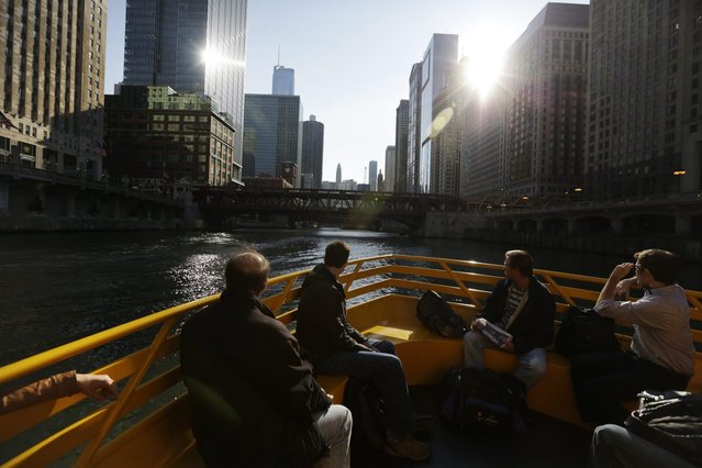 In this September 19, 2014, photo, morning commuters ride a water taxi up the Chicago River to Michigan Avenue in Chicago. (Photo by M. Spencer Green/AP Photo)