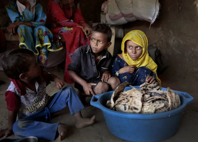In this October 1, 2018 file photo, children sit in front of moldy bread in their shelter, in Aslam, Hajjah, Yemen.   The U.N. children’s agency says that millions of Yemeni children could be pushed to “the brink of starvation” as the coronavirus pandemic sweeps across the war-torn Arab country amid a huge drop in humanitarian aid funding. UNICEF on Friday, June 26, 2020 released a new report, “Yemen five years on: Children, conflict and COVID-19”. (Photo by Hani Mohammed/AP Photo/File)