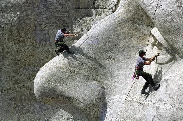 Bob Crisman and Karl Bachman, National parks Service rangers, do some preservation work on the Jefferson sculpture of the presidential monument at Black Hills' Mount Rushmore, SD, June 15, 1992. The Mount Rushmore Preservation Fund upgrades the facility annually. (Photo by Jim Mone/AP Photo)