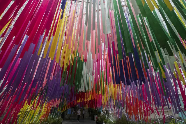 People walk under colorful ribbons at a same s*x charity event in Bangkok, Thursday, July 9 , 2020. Thailand's Cabinet has approved two draft bills that would give same-s*x unions legal status similar to that of heterosexual marriages. (Photo by Sakchai Lalit/AP Photo)