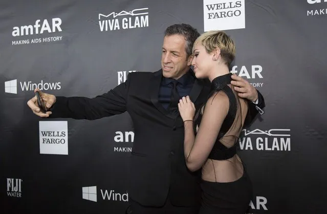 Fashion designer Kenneth Cole takes a selfie with singer Miley Cyrus at the amfAR's Fifth Annual Inspiration Gala in Los Angeles, California October 29, 2014. (Photo by Mario Anzuoni/Reuters)