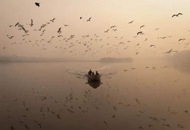 A man sails his boat amidst heavy smog in the Yamuna river, in the old quarters of Delhi, India on November 4, 2022. On November 4 at 08:00 IST, Patparganj, the closest monitoring station, registered a PM 2.5 reading of 500, maxing out the scale. (Photo by Adnan Abidi/Reuters)