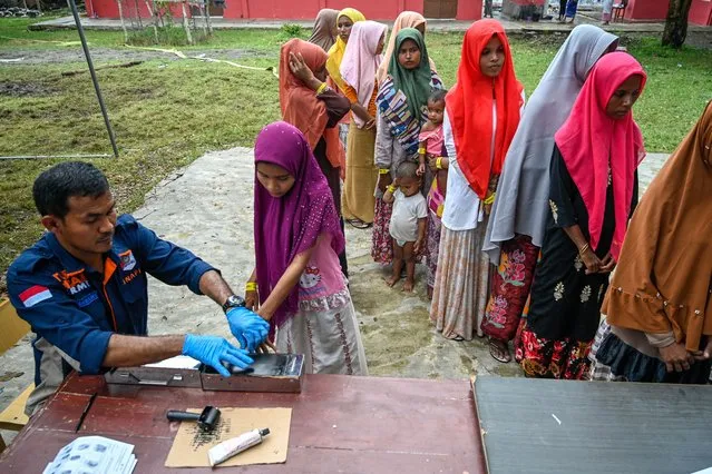 Rohingya refugees register their identities with Indonesian immigration officers at a temporary shelter in Laweueng, Aceh province on December 29, 2022. Nearly 200 Rohingya refugees arrived by boat in Indonesia on December 27, the fourth such landing in the country in recent months. (Photo by Chaideer Mahyuddin/AFP Photo)