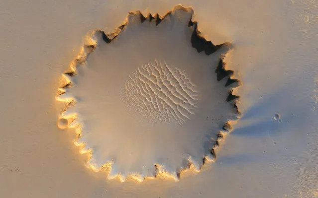 NASA's rover Opportunity visits Victoria Crater, viewed from orbit by the High Resolution Imaging Science Experiment on NASA's Mars Reconnaissance Orbiter in october of 2006. Opportunity is a small dot on the crater's lip, at top right. Opportunity first reached the crater's rim on September 27, 2006. (Photo by NASA/JPL-Caltech/University of Arizona/The Atlantic)