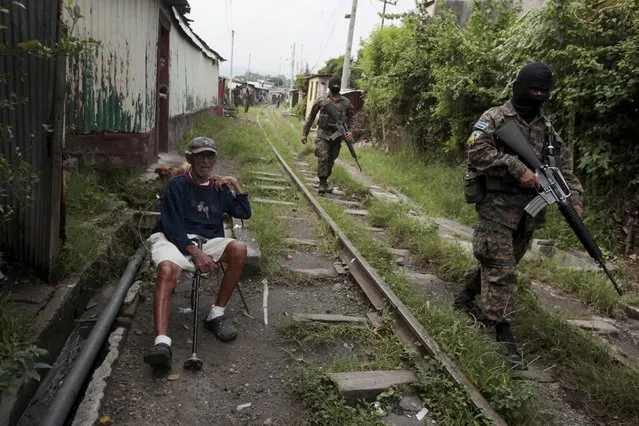 Army soldiers patrol after residents flee the Amaya Community, due to threats from suspected gang members, in San Salvador, October 13, 2015. Around 10 families were threatened with death by suspected members of the MS 13 gang if they do not leave their houses. Many in El Salvador have been displaced from their homes due to gang-related threats, according to local media. (Photo by Jose Cabezas/Reuters)
