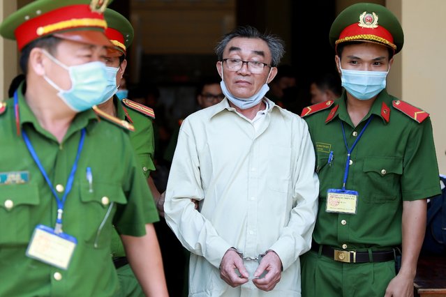 Vietnamese man Nguyen Khanh (C), is escorted by police personnel after a trial where he was sentenced to 24 years in prison for “terrorism” at a court in Ho Chi Minh City on September 22, 2020. Twenty people, including a Nguyen Khanh and son, were jailed September 22 for the bombing of a police station in Ho Chi Minh City on June 2018 that injured three people, state media said. (Photo by Hoang An/AFP Photo)