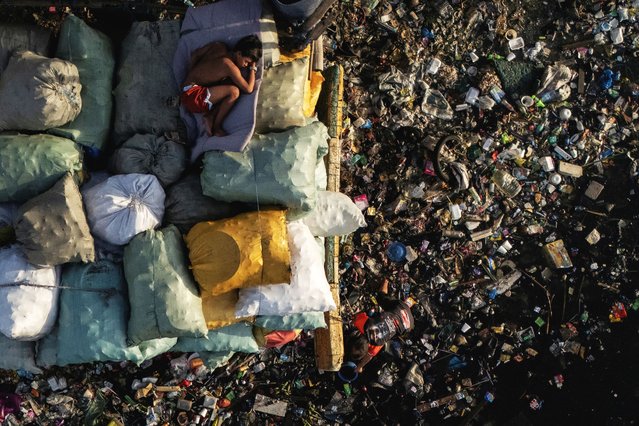 A drone view shows a boy sleeping on sacks of garbage along the polluted Pasig River on World Environment Day in Manila, Philippines, on June 5, 2025. (Photo by Eloisa Lopez/Reuters)