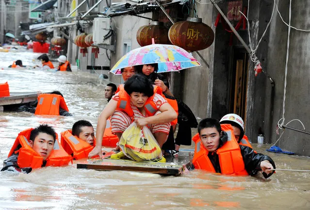 Rescuers evacuate residents through floodwaters brought by typhoon Megi in Ningde, eastern China's Fujian province on September 28, 2016. Typhoon Megi smashed into the Chinese mainland on September 28 morning, killing one person, after leaving a trail of destruction and four people dead in Taiwan. (Photo by AFP Photo/Stringer)