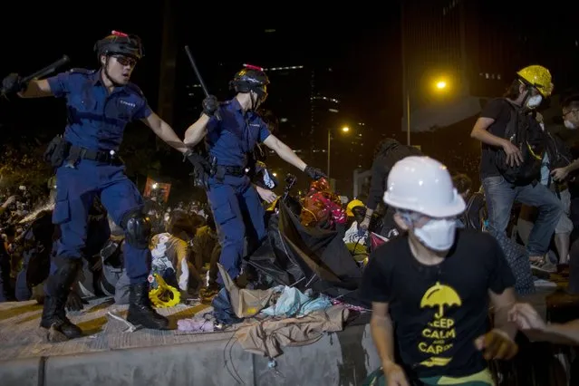 Riot police hold batons as they attempt to clear pro-democracy protesters from a demonstration site close to the chief executive office in Hong Kong December 1, 2014. (Photo by Tyrone Siu/Reuters)