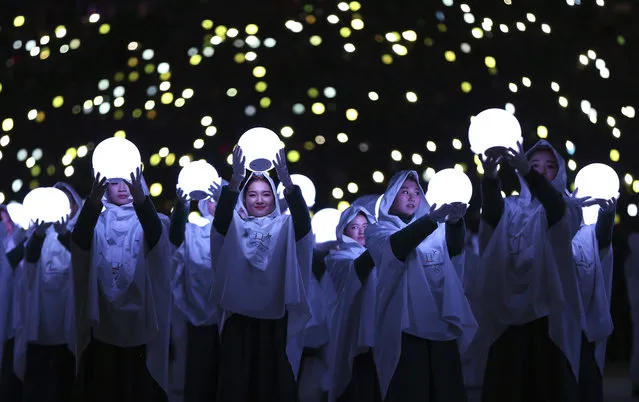 Performers carry lights during the closing ceremony of the 2018 Winter Olympics in Pyeongchang, South Korea, Sunday, February 25, 2018. (Photo by Natacha Pisarenko/AP Photo)