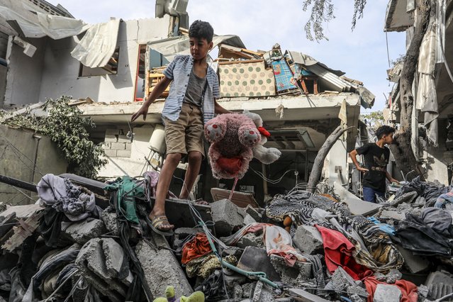 Palestinians, including children, examine the destroyed and damaged buildings and the damaged area around them collect remaining belongings from the rubble of heavily damaged buildings after Israeli attacks on house of Elcamel family in Rafah, Gaza on April 25, 2024. (Photo by Abed Rahim Khatib/Anadolu via Getty Images)