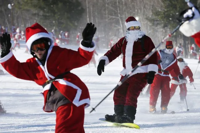 Skiers and snowboarders dressed as Santa participate in a charity run down a slope at Sunday River Ski Resort in Newry, Maine December 7, 2014. (Photo by Brian Snyder/Reuters)