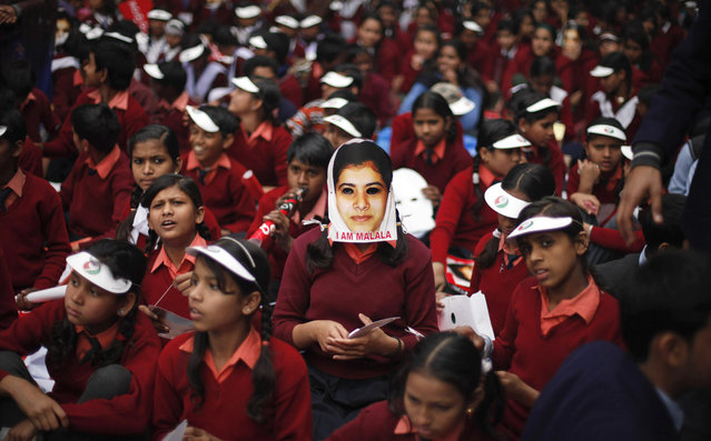 An Indian schoolgirl wears a mask of Malala Yousufzai, a 15-year-old girl who was shot at close range in the head by a Taliban gunman in Pakistan, during a campaign to demand better budgetary allocation for health and education of Indian children in New Delhi, India, on February 2, 2013. (Photo by Altaf Qadri/AP Photo /The Atlantic)