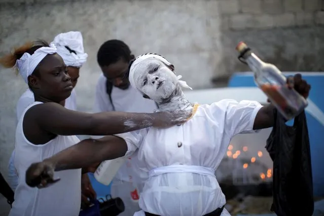 A Voodoo believer gestures as she gets her face covered in baby powder during celebrations at a cemetery in Port-au-Prince, Haiti, November 1, 2020. (Photo by Andres Martinez Casares/Reuters)