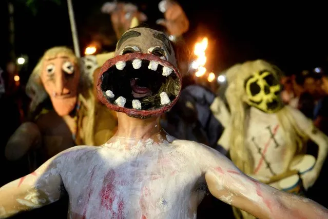 Young revelers take part in a parade called "La Calabiuza" on November 1, 2015, on the eve of the Day of the Dead in Tonacatepeque, 20 kms (13 miles) north of San Salvador. During the celebration, the residents of Tonacatepeque, originally an indigenous community, recall the characters from the mythology of Cuscatlan – pre-Columbian west and central regions of El Salvador – and their dead relatives. (Photo by Marvin Recinos/AFP Photo)