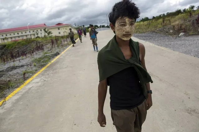 Workers walk on a road as China's oil pipeline project is seen in the background on Madae island, Kyaukpyu township, Rakhine state, Myanmar October 7, 2015. (Photo by Soe Zeya Tun/Reuters)