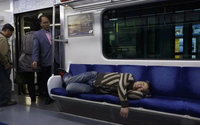 A passenger sleeps in a subway train in Seoul, South Korea Friday, April 19, 2013. (Photo by Kin Cheung/AP Photo)