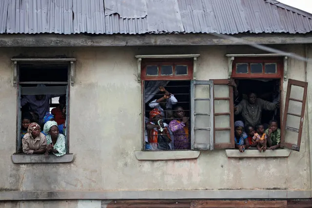 People watch a traditional rite from windows on the first day of Olojo festival in Ile-Ife, Nigeria, October 14, 2016. (Photo by Akintunde Akinleye/Reuters)