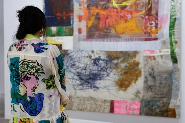 A woman looks at an artwork titled “Communal Play” by Oscar Murillo at Art Basel in Hong Kong, China on March 23, 2023. (Photo by Tyrone Siu/Reuters)
