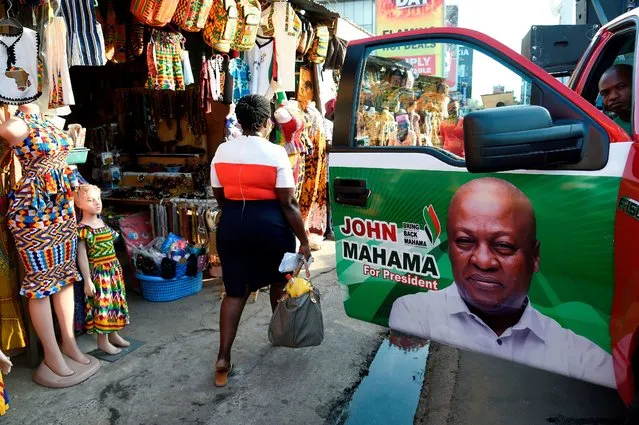 A woman walk past a campaign poster, pasted on car door, of former president and National Democratic Congress (NDC) candidate John Dramani Mahama in Accra on December 3, 2020. Ghanaians will go to the polls on December 7, 2020 in a heated contest that will revive old rivalries between incumbent President Nana Akufo-Addo and his predecessor John Dramani Mahama. (Photo by Pius Utomi Ekpei/AFP Photo)