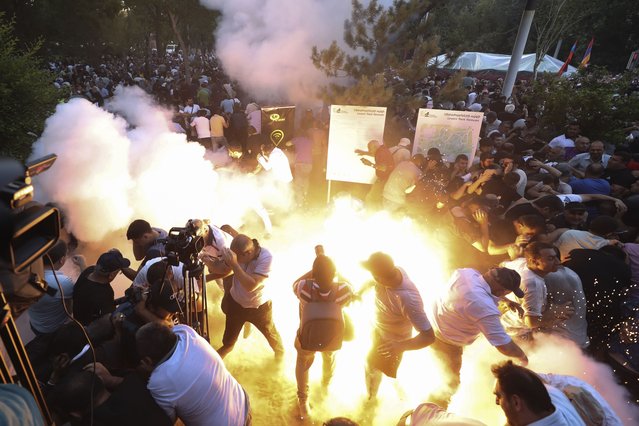 A police stun grenade explodes during a rally against Prime Minister Nikol Pashinyan in Yerevan, Armenia, Wednesday, June 12, 2024. (Photo by Vahram Baghdasaryan/Photolure via AP Photo)