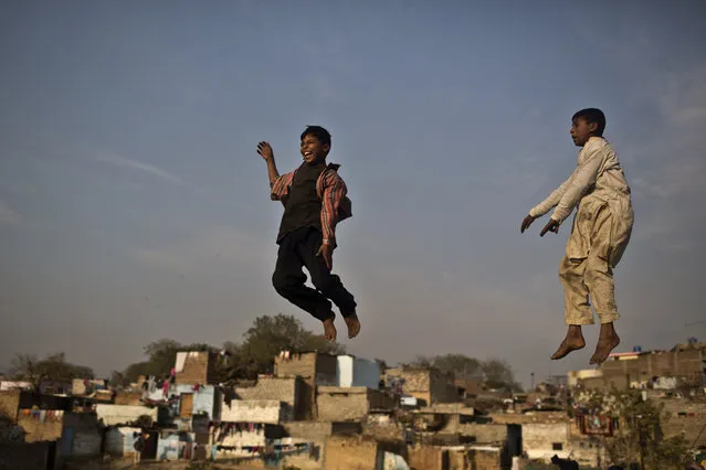Pakistani boys enjoy jumping on a trampoline, at a makeshift entertainment park set up in a Christian neighborhood for Christmas holiday, in Islamabad, Pakistan, Tuesday, December 23, 2014. (Photo by Muhammed Muheisen/AP Photo)