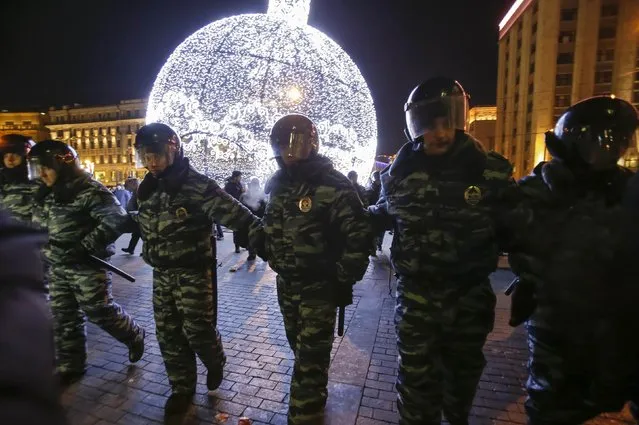 Policemen block supporters of Russian opposition leader and anti-corruption blogger Alexei Navalny during a rally in protest against court verdict next to a festive decoration at Manezhnaya Square in Moscow December 30, 2014. (Photo by Tatyana Makeyeva/Reuters)