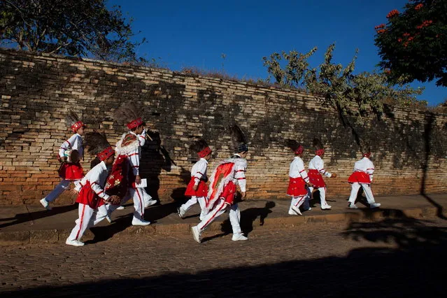 Boys dressed in traditional costume, walk to the “Cavalhadas” festival, in Pirenopolis, Brazil, Sunday, May 19, 2013. The popular festival is a tradition that was introduced in the 1800's by a Portuguese priest to mark the the ascension of Christ. The 3-day festival reenacts the Christian knights' defeat of the Moors. (Photo by Eraldo Peres/AP Photo)