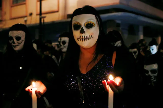 A woman wears a skeleton mask during a procession organized by s*x workers to remember their deceased colleagues, especially those who were violently murdered, as part of the celebrations ahead of the Day of the Dead, in Mexico City, Mexico October 28, 2016. (Photo by Ginnette Riquelme/Reuters)