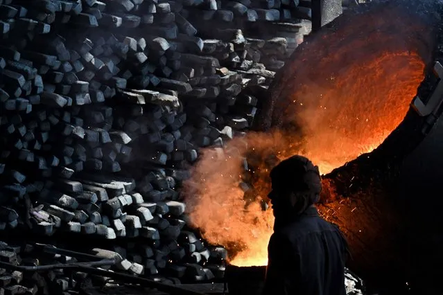 A labourer works at an iron factory in Lahore on April 30, 2023. (Photo by Arif Ali/AFP Photo)