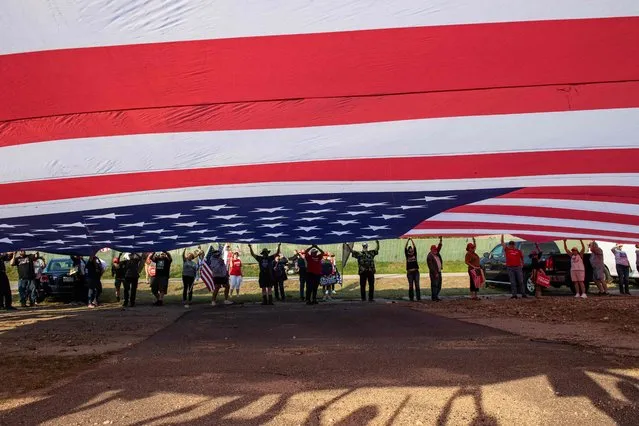Supporters of former US President and 2024 Presidential hopeful Donald Trump rally to welcome him at Manchester airport in Manchester, New Hampshire, on May 10, 2023 ahead of his CNN town hall meeting. (Photo by Joseph Prezioso/AFP Photo)