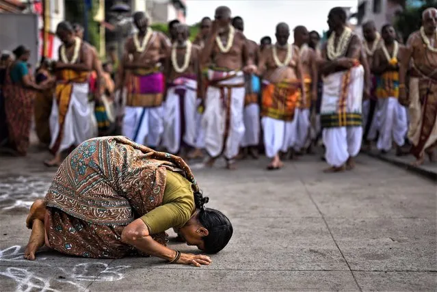 A Hindu devotee seeks blessings from the Adhyapakas (religious preceptors) during a chariot procession on the occasion of the Chithirai Brahmotsavam festival, at Parthasarathy temple, in Chennai, 10 May 2023. Hundreds of Hindu devotees take part in a procession on the occasion of the Chithirai Brahmotsavam festival in the neighborhood of Triplicane. The Tamil calendar month of Chithirai commenced with the Chariot festival at the Parthasarathy temple, a 6th-century Hindu Vaishnavite temple dedicated to Lord Vishnu. Vaishnava devotees chant sacred Vedas and offer prayers to the Lord Parthasarathy. (Photo by Idrees Mohammed/EPA/EFE)