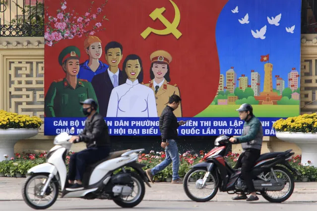People ride motorcycles past a poster promoting the Communist Party Congress in Hanoi, Vietnam, Saturday, January 23, 2021. (Photo by Hau Dinh/AP Photo)