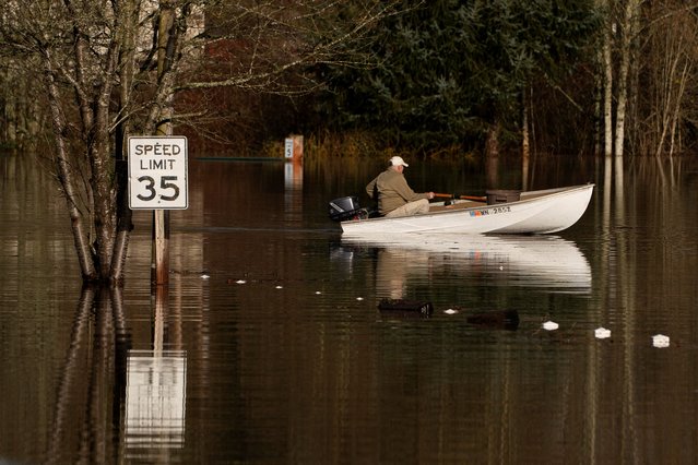 Bob Peterson uses a boat to search for items that floated away from a little league baseball field in an area flooded by the Snoqualmie River in Fall City, Washington, on December 9, 2025. (Photo by David Ryder/Reuters)