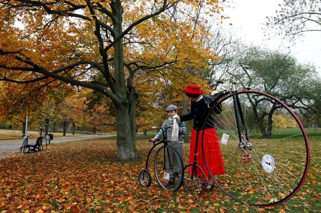 A woman and a child wearing historical costumes stand with their high-wheel bicycles before the annual penny farthing race in Prague, Czech Republic November 5, 2016. (Photo by David W. Cerny/Reuters)