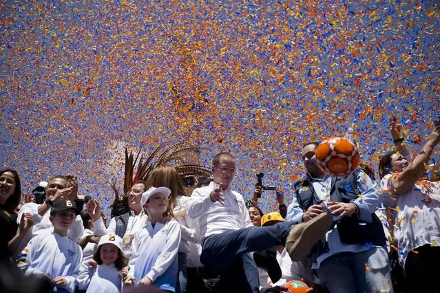 Presidential candidate Ricardo Anaya, of the left-right coalition Forward for Mexico, kicks a soccer ball to supporters under falling confetti during his campaign rally in Mexico City, Sunday, June 24, 2018. Mexico's four presidential candidates are holding their last weekend of campaigning before the country's July 1 elections. (Photo by Ramon Espinosa/AP Photo)
