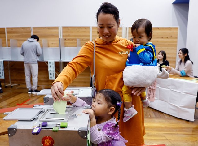 A woman accompanying her children in Halloween costume casts her ballot in the general election at a polling station in Tokyo, Japan on October 27, 2024. (Photo by Kim Kyung-Hoon/Reuters)