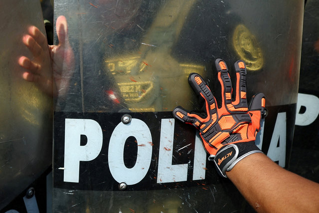 A police officer clashes with a demonstrator near the National Congress as members of unions and social organizations, protest as part of a 3-day national strike, on the sidelines of the Asia-Pacific Economic Cooperation (APEC) summit, in Lima, Peru on November 13, 2024. (Photo by Agustin Marcarian/Reuters)