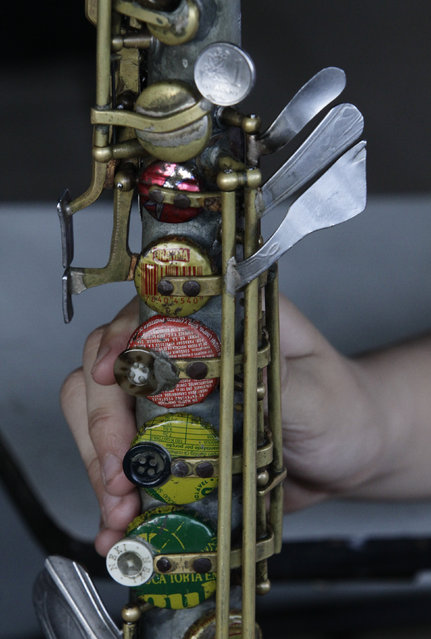 A student of the Orchestra of Recycled Instruments of Cateura holds an instrument made from recycled material by craftsman Nicolas Gomez, in Cateura, near Asuncion, May 9, 2013. The orchestra is the brainchild of its conductor Favio Chavez, who wanted to help the children of garbage pickers at the local landfill, and the instruments are made from salvaged materials by craftsman Gomez. (Photo by Jorge Adorno/Reuters)