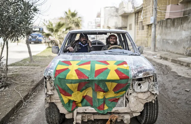 A Kurdish fighter smiles as he drives a car in the center of the Syrian border town of Kobane, known as Ain al-Arab, on January 28, 2015. Kurdish forces recaptured the strategic town on the Turkish frontier on January 26 in a symbolic blow for the jihadists who have seized swathes of territory in a brutal onslaught across Syria and Iraq. (Photo by Bulent Kilic/AFP Photo)