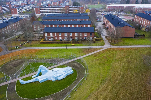This aerial view photo shows one of two “Varbergs Giants”, a giant sculpture by French artist Xavier Veilhan displayed in Varberg, south of Stockholm on November 12, 2020. French artist Xavier Veilhan won the first prize in the art competition of the city of Stockholm announced in 2018 as part of the urban development project Fokus Skarholmen. The giants together consist of 89 large sky-blue concrete blocks assembled into finished sculptures. The largest blocks weigh six tons each. (Photo by Jonathan Nackstrand/AFP Photo)