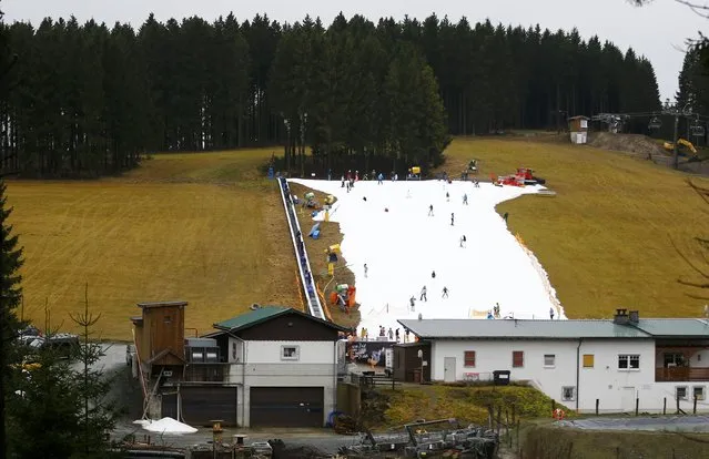 Visitors ski on a piste made with artificial snow by a snow cannon during warm weather in the western German ski resort of Winterberg some 80km southeast of Dortmund, Germany December 22, 2015. (Photo by Wolfgang Rattay/Reuters)