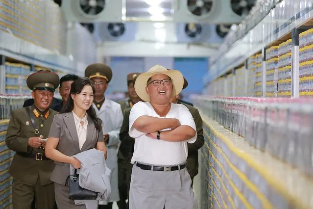 This undated picture released by North Korea' s official Korean Central News Agency (KCNA) on August 8, 2018 via KNS shows North Korean leader Kim Jong Un (R) inspecting the Kumsanpho Fish Pickling Factory with his wife Ri Sol Ju (2nd L) in South Hwanghae Province, North Korea. (Photo by AFP Photo/KCNA via KNS)