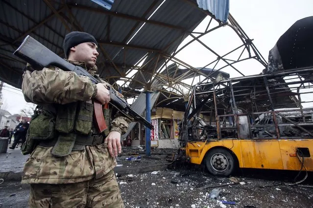 A member of the armed forces of the separatist self-proclaimed Donetsk People's Republic stands guard near a destroyed vehicle at a bus station after shelling in Donetsk, February 11, 2015. At least one person was killed on Wednesday when a shell hit a bus station in the centre of rebel-controlled Donetsk city, east Ukraine, a Reuters witness said. (Photo by Maxim Shemetov/Reuters)