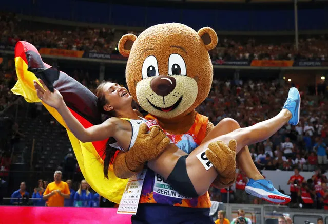 Germany's Gesa-Felicitas Krause is lifted by mascot Berlino as she celebrates after winning the gold medal in the women's 3000-meter steeplechase at the European Athletics Championships in the Olympic stadium in Berlin, Germany, Sunday, August 12, 2018. (Photo by Matthias Schrader/AP Photo)
