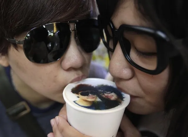 A couple drinks a cup of latte with their picture printed on top of the milk foam at a Family Mart in Taipei August 13, 2013. As part of Qixi Festival celebrations, customers of Family Mart's Let's Cafe were given the complimentary service of getting their pictures printed with edible inks on their lattes, according to a Family Mart employee. Qixi, also known as the Double Seventh Festival and the Chinese version of Valentine's Day, falls on the seventh day of the seventh month in the Chinese lunar calendar. (Photo by Pichi Chuang/Reuters)